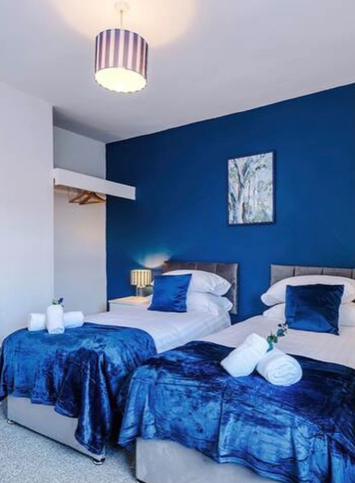 Styled twin bedroom with blue velvet bedding by MATTAM Property Services