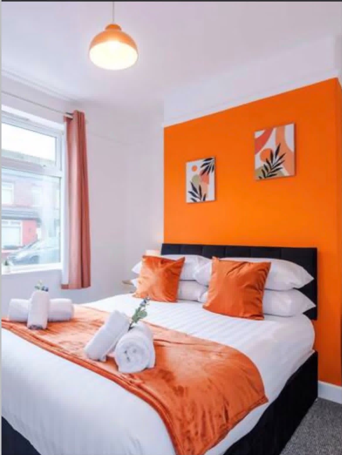Bedroom after styling by MATTAM Property Services, bold orange feature wall
