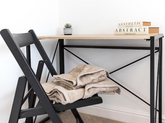 Styling detail, desk corner with folded towels and books